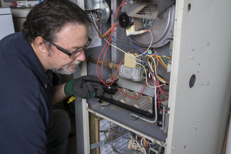 man inspecting furnace