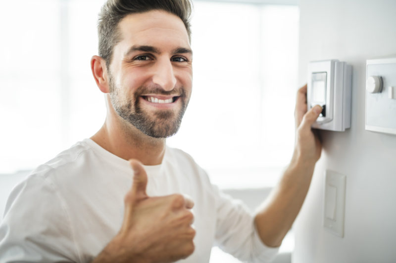 happy man setting the thermostat