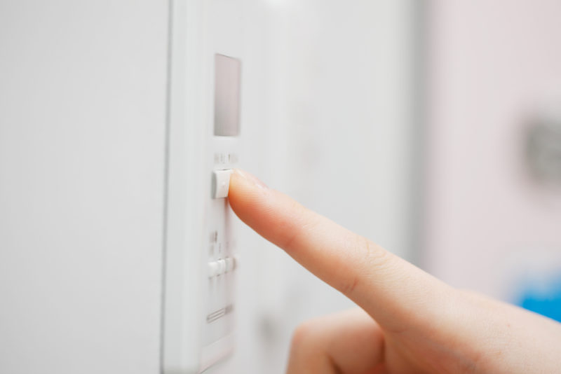 person setting thermostat