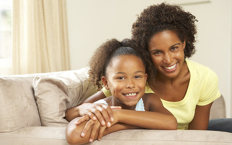 Mom And Daughter Sitting On Couch