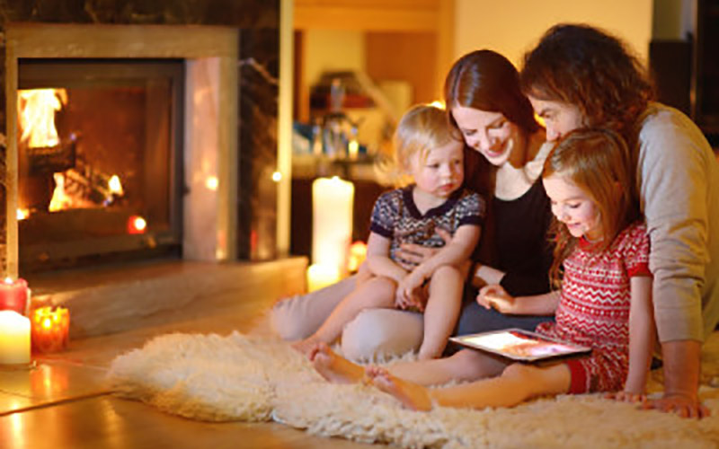 Family Sitting On Floor Looking At Tablet